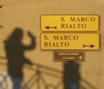 One street sign pointing left reads "S. Marco Rialto", below it another street sign reading "S. Marco Rialto" points to the right.